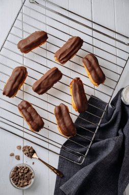 Beyaz ahşap masanın üzerinde serinletici bir rafta duran mini çikolatalı ekler, düz bir manzara. Yüksek kalite fotoğraf