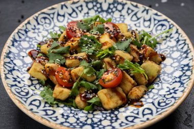 Kiraz domatesli çıtır patlıcan salatası, otlar ve desenli kasede susam sosu. Yüksek kalite fotoğraf