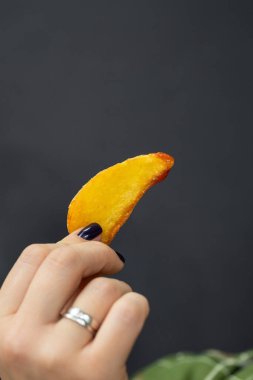 El ele tutuşup arka planda ketçaplı çıtır bir patates dilimi tutuyoruz. Yüksek kalite fotoğraf