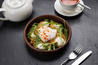 Haşlanmış yumurta, kabaklı börek, roka ve siyah arkaplanda çay ile sağlıklı bir kahvaltı. Yüksek kalite fotoğraf