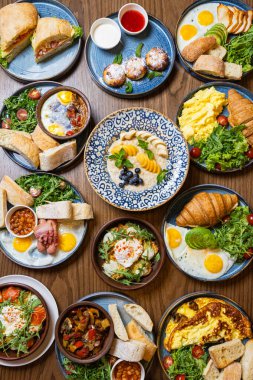 Kırsal ahşap bir masa üzerinde çeşitli gurme kahvaltı yemekleri, üst manzara. Yüksek kalite fotoğraf