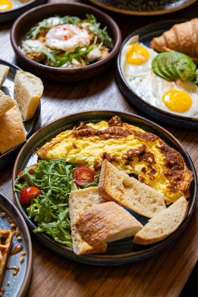 Здоровый завтрак с омлетом, чиабатта, салатом и чаем на тёмном каменном фоне. Высокое качество фото