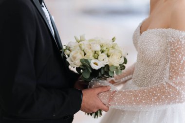 Şık gelin ve damat düğün günlerinde ellerinde buket ve el tutuyorlar. Yüksek kalite fotoğraf