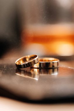 Aynada iki altın alyans, sıcak romantik ışık ve yumuşak arka plan bulanıklığı. Yüksek kalite fotoğraf