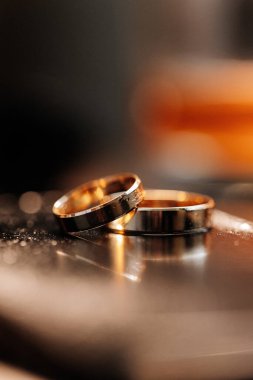 Aynada iki altın alyans, sıcak romantik ışık ve yumuşak arka plan bulanıklığı. Yüksek kalite fotoğraf