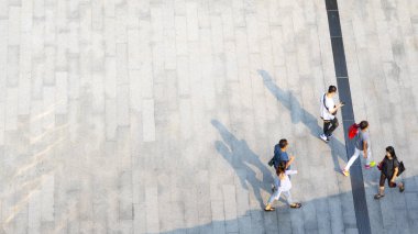 İnsanlar zeminde siyah siluet gölgesi olan yaya beton arazisinde yürür (üst hava manzarası))