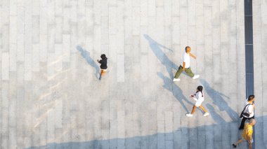 İnsanlar zeminde siyah siluet gölgesi olan yaya beton arazisinde yürür (üst hava manzarası))