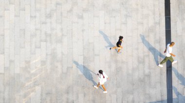 İnsanlar zeminde siyah siluet gölgesi olan yaya beton arazisinde yürür (üst hava manzarası))