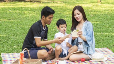 Çocuk Anne ve babayla park house kutusu kaydetme para tutun. Mutlu aile pikniği kavramı.