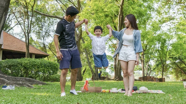 Söt Pojke Hoppa Och Hålla Hand Mor Och Far Park — Stockfoto