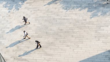 İnsanlar zeminde siyah siluet gölgesi olan yaya beton arazisinde yürür (üst hava manzarası))