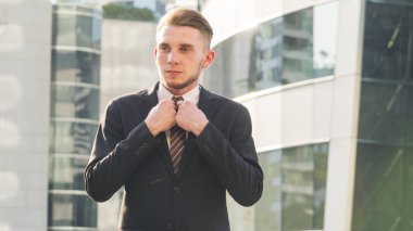 iş kendine güvenen adam stand akıllı ve belgili tanımlık maiyet açık kamusal alan modern bina arka plan ile giysi