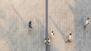İnsanlar zeminde siyah siluet gölgesi olan yaya beton arazisinde yürür (üst hava manzarası))
