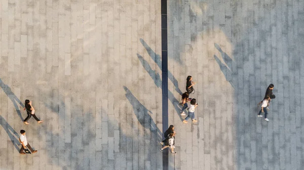 Bulanık insanlar yerde siyah gölgeli yaya üzerinde yürür (üst hava görüntüsü))