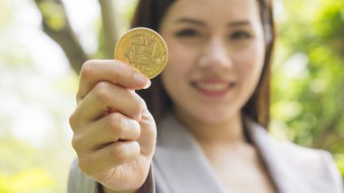 bitcoins - Bitcoin dijital para gelecek merak göstermek için rahat bir iş kadını elinde.