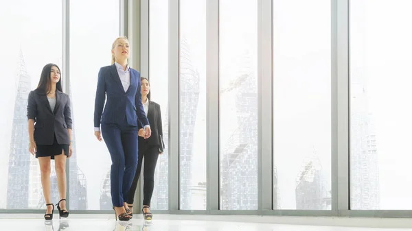 精明的女性商务人士步行在走廊办公室与装配玻璃背景和现代建筑 团队合作的成功理念 — 图库照片