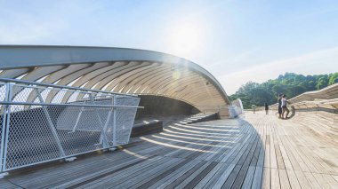 ahşap köprü geçit gölge güneş ışığı orman ağacı yeşil alanın kentsel modern şehir ve mavi gökyüzü beyaz bulut üzerinde çelik yapısı ile insanlarda