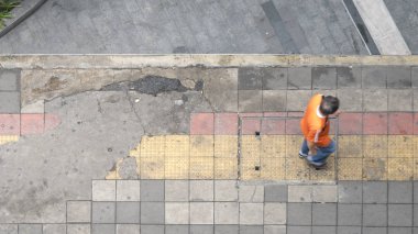 Havadan görünümü ve üstten görünüm ile adam yürüyüş iş alanında yaya cadde ve kırmızı ve sarı blok kaldırım ile bulanıklık