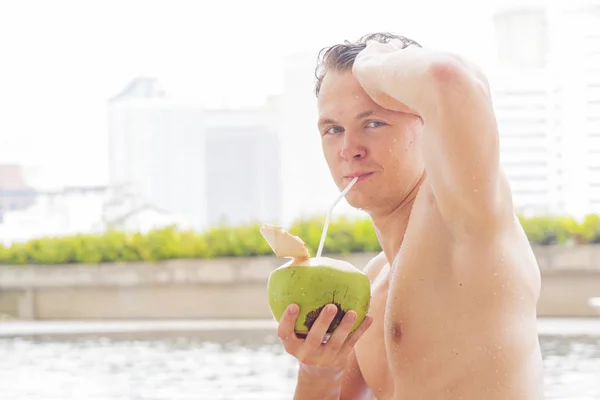 white man muscle nude topless with coconut drink at swimming pool in fresh feeling
