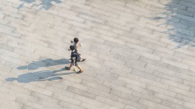 Top havadan görünümü altında insanlar yürüyüş üzerinde yaya beton zemin üzerinde siyah siluet gölge ile arasında bulanıklık