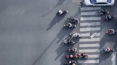 Motosiklet sürerken çekilen hava fotoğrafı trafik yolunda yaya geçidini ışık ve gölge silueti ile geçiyor.