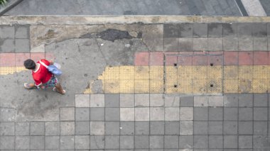 Havadan görünümü ve üstten görünüm ile adam yürüyüş iş alanında yaya cadde ve kırmızı ve sarı blok kaldırım ile bulanıklık