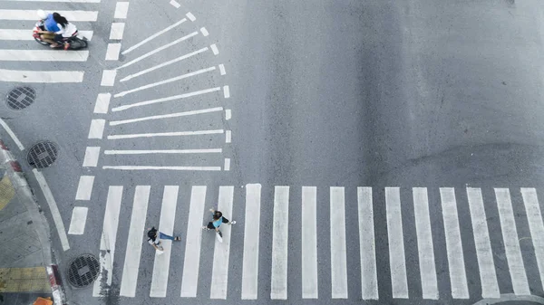 人群走在街上行人十字路口的城市街道上 摩托车驾车经过马路 从顶部看 鸟瞰图 — 图库照片