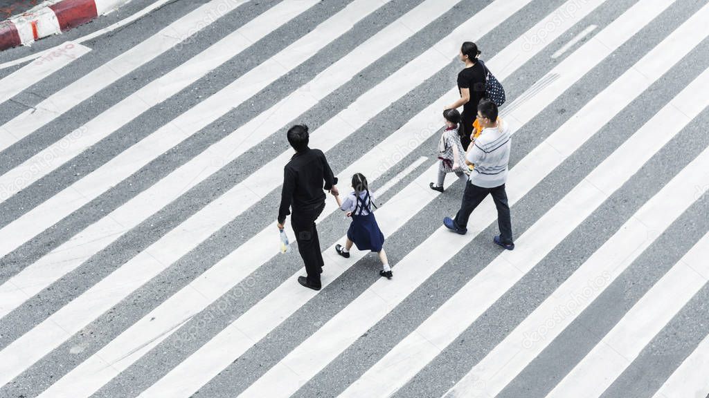 Crowd of people and group of family with child walk on street pedestrian crossroad in the city street ,from top view ,bird eye view.