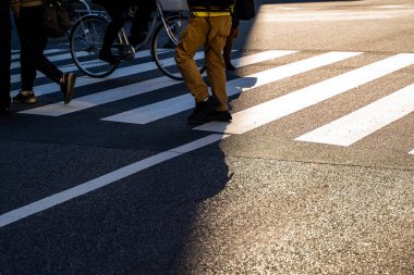 Silüet üst görünümü insanlar yaya yaya yaya geçidinde yürüyorlar akşam gün batımında caddede karanlık bir gölgeyle.