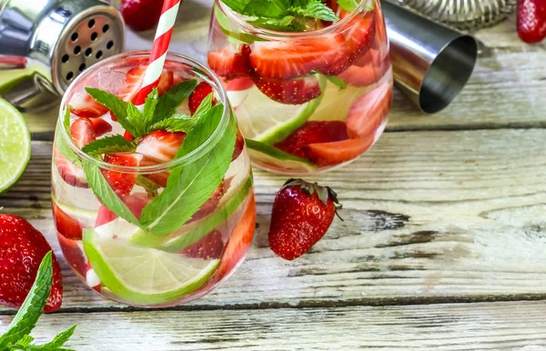 fresh lemonade with strawberries , lime and mint on a wooden background with copy space for background or wallpaper. Fresh and cool beverage for summer concept.