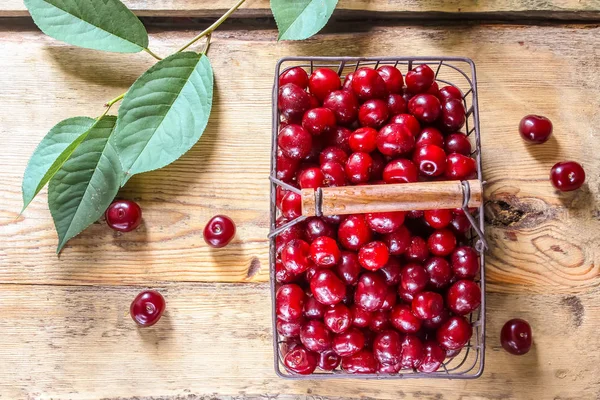 Cherries on wooden table with water drops