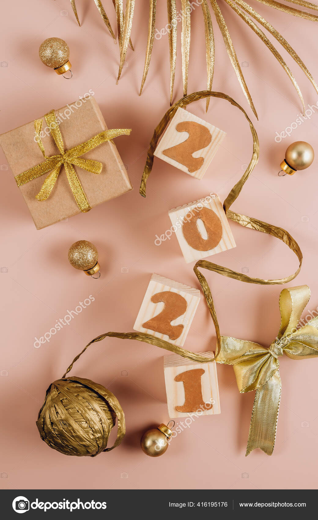 精美的圣诞背景带有金色圣诞装饰品礼品盒和木制方块并在粉末状粉底上刻上21年的字样平躺在床上顶部视图