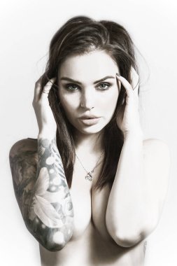 Üstsüz dövmeli seksi bir kızın erotik portresi.