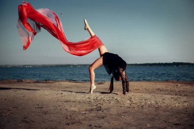 Kumsalda elinde kırmızı bir bezle güzel bir kız.