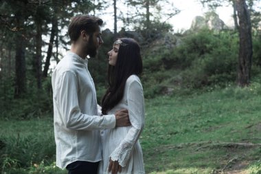 Aşık genç güzel Slav çift ormanda, bir basit boho-tarzı gelinlik tatlı kız yürüyor. Onlar mutlu ve sakin vardır. Yaz gün, sıcak, altın saat. Onlar öp, sarılmak ve el ele.