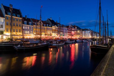 Gece Kopenhag 'da Nyhavn su kanalı ve turistik cadde