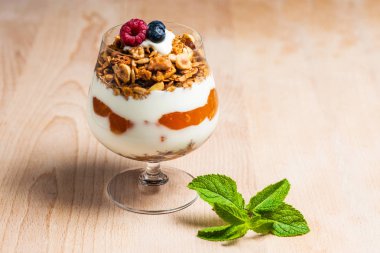 Yoğurt krem, çilek ve cam beyaz masada servis müsli