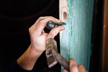 Install iç ahşap kapı kapı kilit adam. Ellerini onarın. Ana bir marangoz adamdır. Araçlarla çalışma.