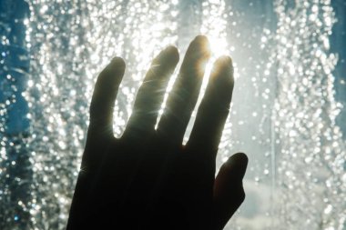 Elin buz gibi pencerenin karşısında karanlık siluet güneş parlamayı parmaklarınla çalış