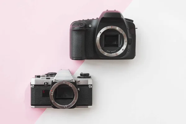 コンセプト - ピンクの背景にアナログ対デジタル一眼レフ カメラ — ストック写真