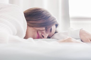 Genç güzel kadının yatak bakarak kamera sığ Dof, yakın çekim 