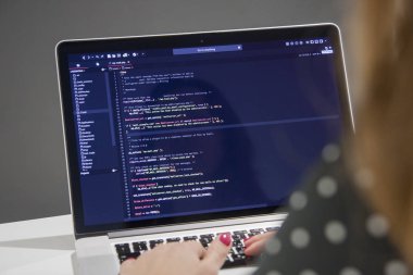 Ofiste dizüstü bilgisayar üzerinde çalışan kahve kadın programcı