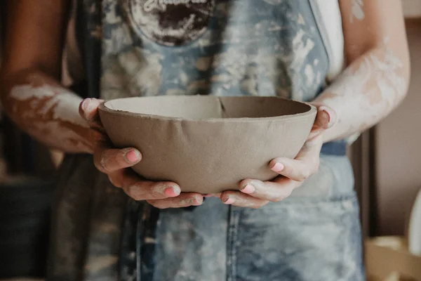 Pottery, clay, ceramics art concept - closeup on hands of young master with the large plate from fireclay — Stock Photo, Image