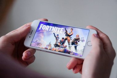 Los Angeles, Kaliforniya, ABD - 8 Mart 2019: Fortnite oyun ile bir akıllı telefon göstermek perde, açıklayıcı yayın holding eller
