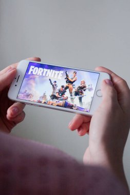 Los Angeles, Kaliforniya, ABD - 8 Mart 2019: Fortnite oyun ile bir akıllı telefon göstermek perde, açıklayıcı yayın holding eller