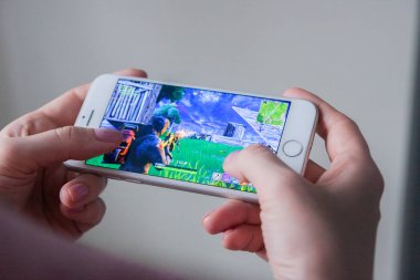 Los Angeles, Kaliforniya, ABD - 8 Mart 2019: Fortnite oyun ile bir akıllı telefon göstermek perde, açıklayıcı yayın holding eller