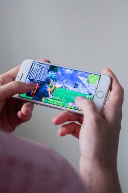 Los Angeles, Kaliforniya, ABD - 8 Mart 2019: Fortnite oyun ile bir akıllı telefon göstermek perde, açıklayıcı yayın holding eller