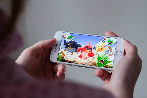 Los Ángeles, California, EE.UU. - 8 de marzo de 2019: Manos sosteniendo un teléfono inteligente con Angry Birds juego en la pantalla, Editorial Ilustrativo — Foto de Stock