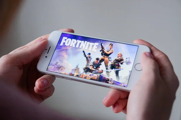 Los Ángeles, California, EE.UU. - 8 de marzo de 2019: Manos sosteniendo un teléfono inteligente con el juego Fortnite en pantalla, Editorial Ilustrativo — Foto de Stock