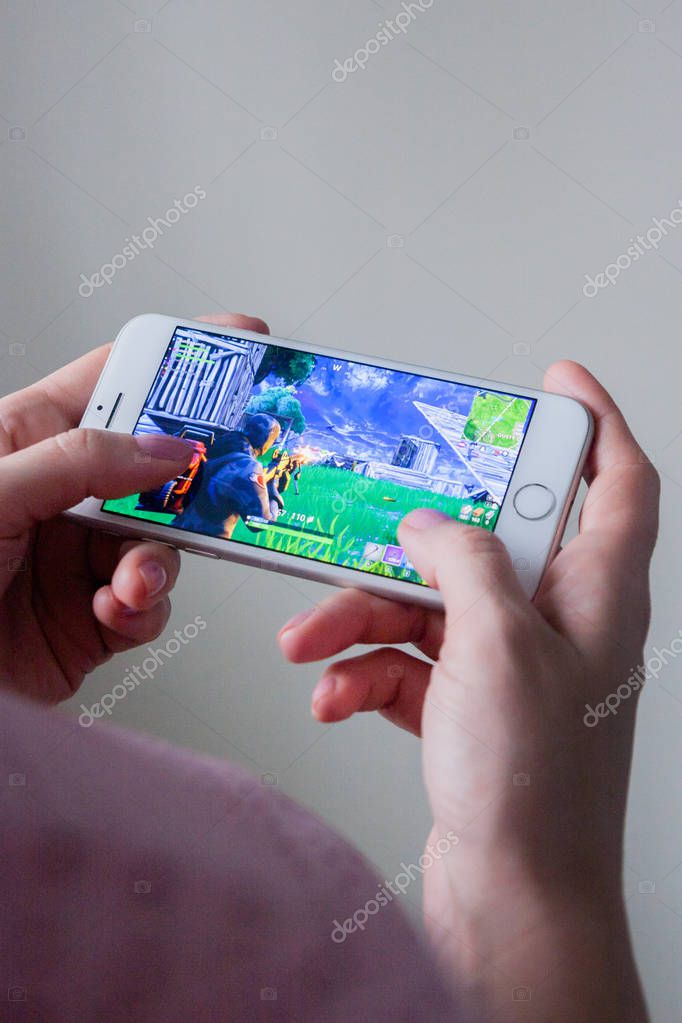 Los Angeles, California, USA - 8 March 2019: Hands holding a smartphone with Fortnite game on screen, Illustrative Editorial